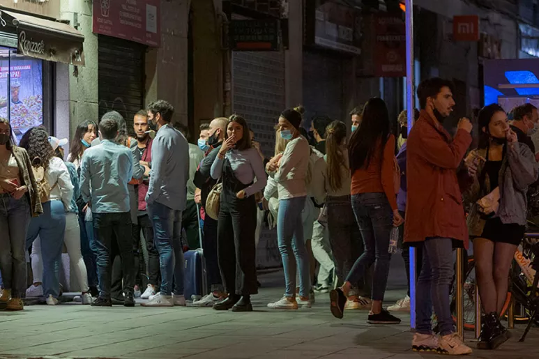Personas haciendo cola en la calle para entrar en un bar
