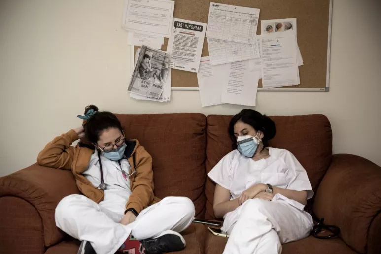 Dos sanitarias se toman un descanso en una sala de un hospital madrileño tras una exhausta jornada durante la primera ola de la pandemia (Foto: Alberto Di Lolli).