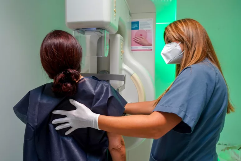 Una mujer se prepara para una mamografía