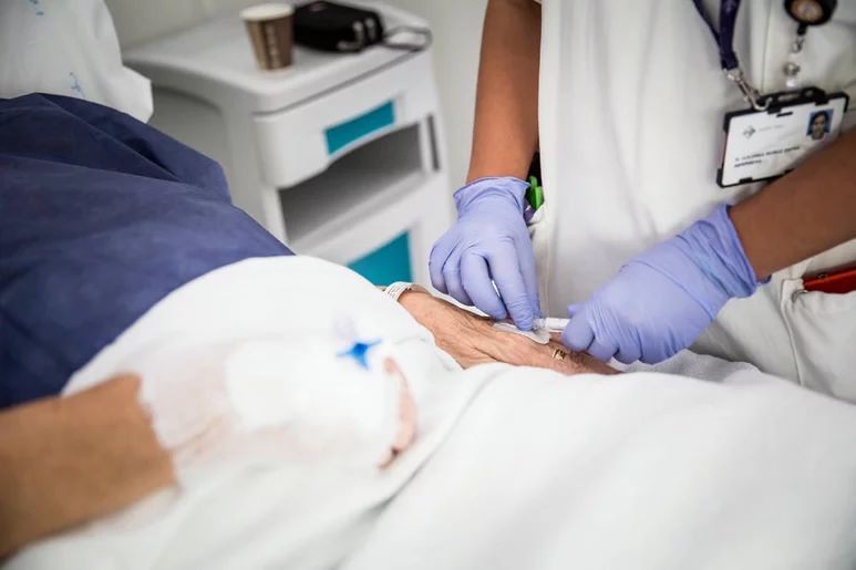 Una enfermera administra medicación por vía venosa a una persona. Foto: ARIADNA CREUS y ÀNGEL GARCÍA (BANC IMATGES INFERMERES)