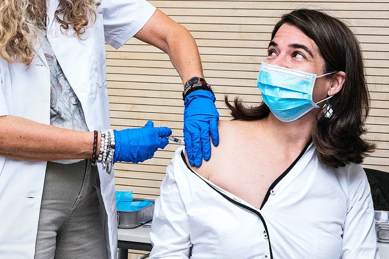 Esther Calvo de Mora, vicepresidenta 2ª del COF de Madrid, vacunándose de la gripe por otra farmacéutica en el COF de Madrid. Foto: LUIS CAMACHO.