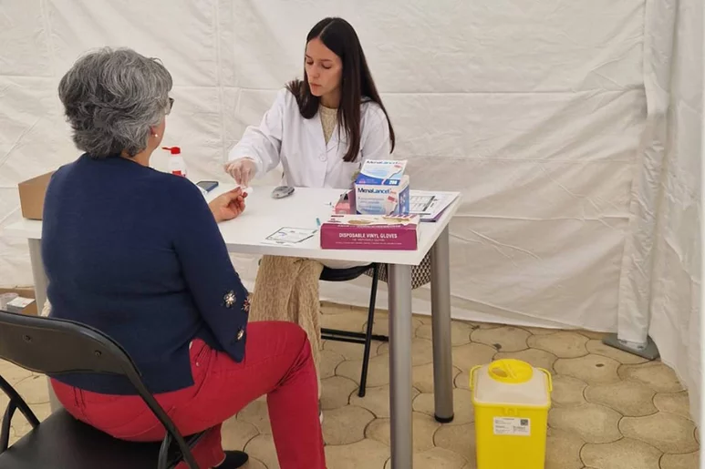 Una farmacéutica atendiendo a una paciente en una de las cuatro carpas instaladas en Vall d’ Albaida (Valencia). Foto: COF DE VALENCIA.