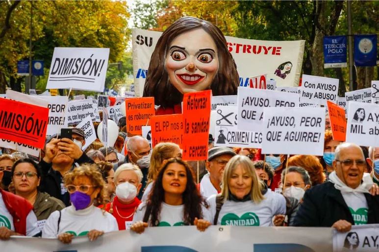 Manifestantes en defensa de la sanidad pública en Madrid, ante la figura de Isabel Díaz Ayuso, presidenta de la Comunidad de Madrid. Foto: SERGIO ENRÍQUEZ-NISTAL.