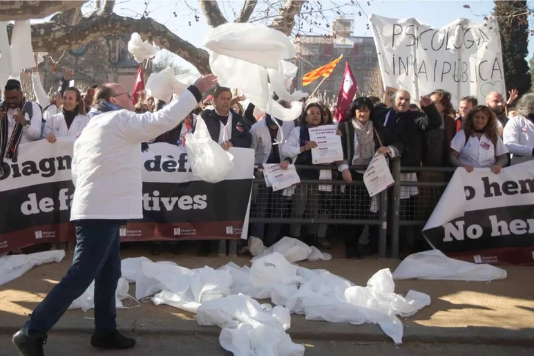 Médicos catalanes tiran al suelo sus batas en un acto simbólico de protesta durante una de las manifestaciones convocadas en Barcelona. Foto: METGES DE CATALUNYA.