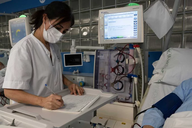 Una sanitaria del Clínic toma notas a mano de un paciente a causa del ciberataque.