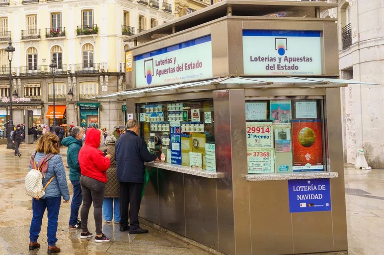 Personas haciendo cola en una administración de lotería en Madrid. Foto: ÁNGEL NAVARRETE