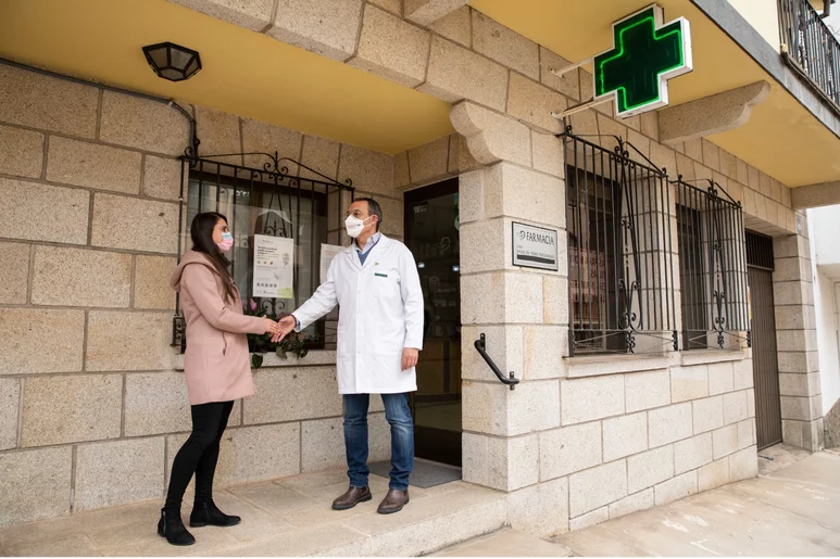 Sefac señala que más del 20% de consultas que se realizan al farmacéutico son de síntomas respiratorios. En la imagen, Emilio de Pedro Pordomingo, con una usuaria en su farmacia de El Arenal (Ávila). Foto: SERGIO GONZÁLEZ VALERO